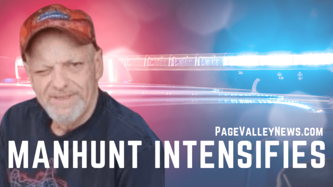 PageValleyNews.com manhunt intensifies News-style graphic: Manhunt intensifies with a picture of Timothy T. Comer and police lights behind him.